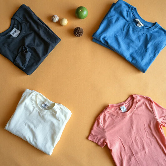 Folded faded vintage t-shirts with visible fabric texture in natural daylight