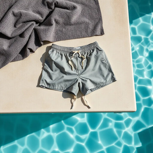 Men’s swim shorts with a short inseam length displayed poolside in natural daylight